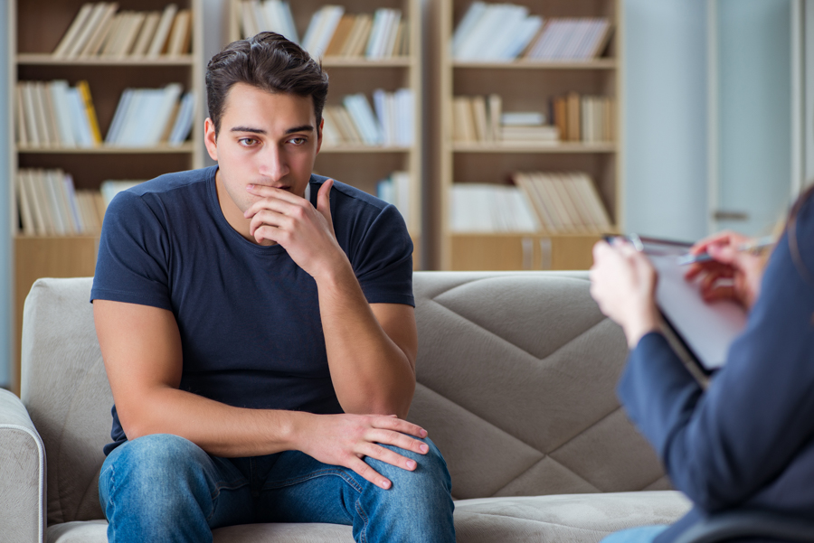 sad man sitting on a couch for addiction treatment