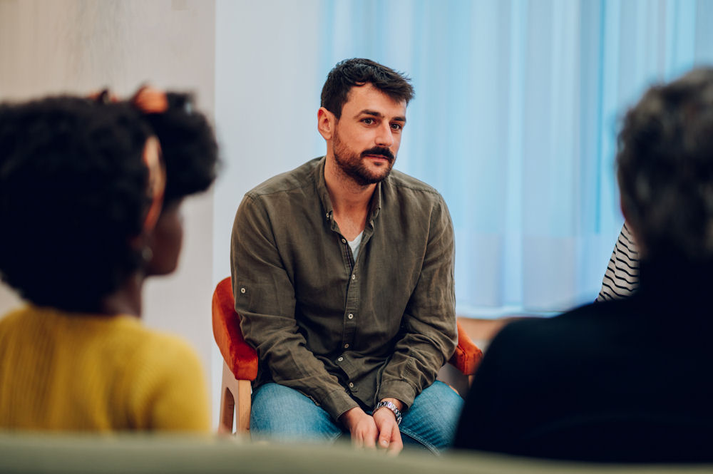 people sitting in chairs for a group therapy session